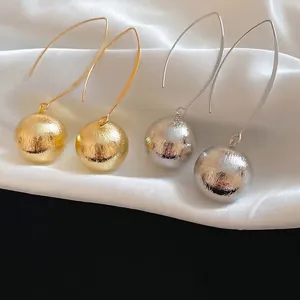 Minimalist metallic ball dangle earrings in gold and silver finish with long curved hooks