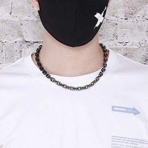 Detail of a black stainless steel O-chain necklace on a model for a street style look