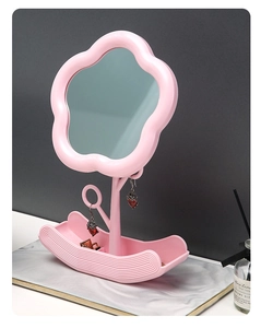 Detailed close-up of pink flower-shaped vanity mirror with wave-patterned storage base