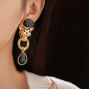 Close-up of vintage leopard head earrings with black rhinestones and teardrop pendants
