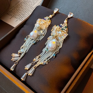 Macro view of bowknot tassel earrings with pearls and rhinestones on jewelry box