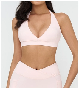 Dettaglio del reggiseno sportivo rosa pallido con scollo a V incrociato e tessuto elastico