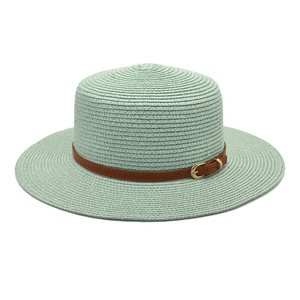 Detail of mint green boater hat featuring fine woven straw and brown leather belt