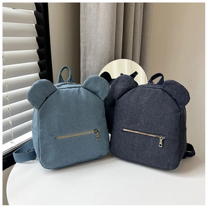 Detail of mini canvas backpacks with bear ears in light blue and dark blue colors
