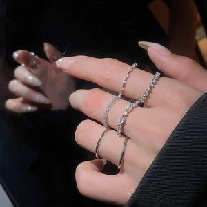 Macro detail of silver geometric rings set featuring sparkling zircons on finger