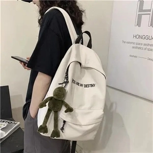 Détail du sac à dos en toile blanche avec imprimé et pendentif peluche grenouille verte