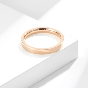 Gros plan d'une bague empilable de 3 mm en acier titane or rose sur un support géométrique