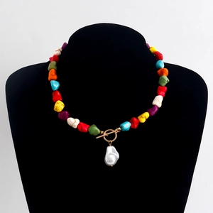 Detail of colorful irregular stone necklace with baroque pearl and golden OT clasp