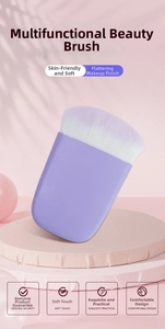 Flat-top purple blush brush with gradient bristles displayed on a pink podium