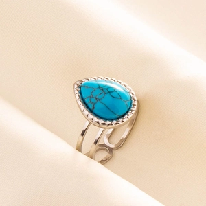 Detail of vintage adjustable ring with pear-shaped turquoise stone and beaded silver edge