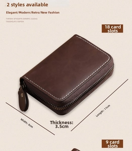 Detail of dark brown leather card wallet showing zipper closure and white stitching seams