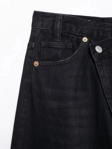 Détail de jean noir avec taille croisée asymétrique à double boutonnage élégante