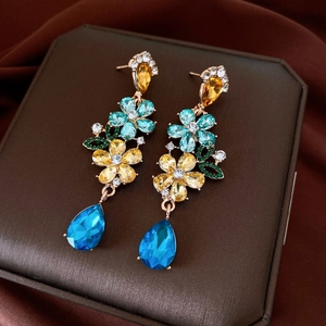 Detailed macro view of vintage floral tassel earrings with multicolored crystals