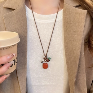 Close-up of ethnic style necklace with red geometric pendant and multi-color beads on model