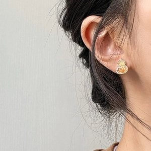 Gourd shaped gold plated earrings with yellow zircon stone and crystals worn by a model