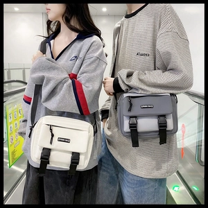 Dual buckle utility messenger bags in cream and grey featuring durable canvas fabric