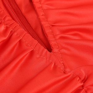 Detail mit verdecktem Reißverschluss und Plisseefalten am roten glänzenden Kleid