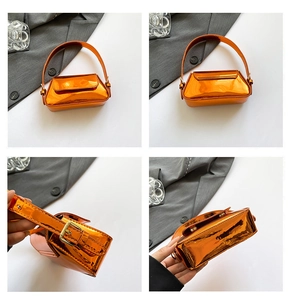 Macro view of metallic orange mini baguette bag with glossy finish and metal buckles