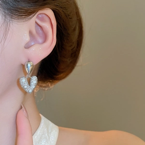 Vue rapprochée de boucles d'oreilles cœur avec cristaux portées par un mannequin