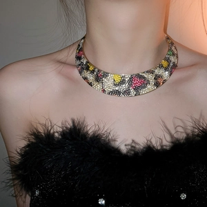 Close-up of golden leopard print choker with colorful rhinestones on a female model