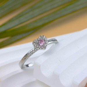 Macro detail of silver heart ring featuring a pink zircon center stone and pave setting