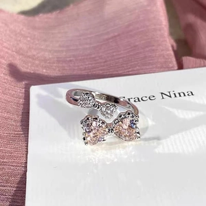 Detail of pink heart stones and pavé bow on adjustable silver bow ring