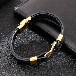 Detailed macro view of black leather bracelet with golden infinity symbol and clasp
