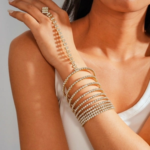 Detailed macro view of gold multi-layer rhinestone bracelet and ring finger chain set