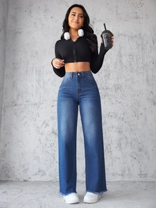 Detail van wijde spijkerbroek met hoge taille, rafelrand en zwarte nauwsluitende crop top