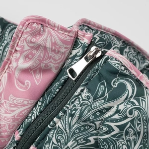 Macro shot of silver zipper detail on pink and green paisley pattern quilted jacket