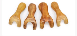 Set of four ergonomic sandalwood gua sha massage tools with natural wood grain and smooth finish