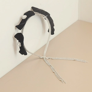 Black velvet headband featuring a rhinestone bow and long tassel for a stylish hair accessory