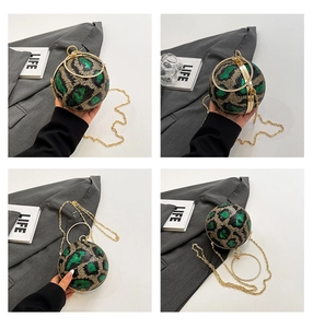 Detail view of spherical evening bag with green sequins and gold ring handles