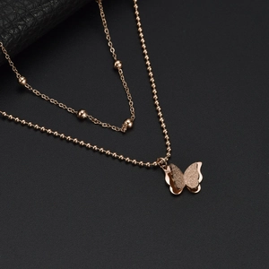 Double-layer rose gold butterfly necklace with bead chain design on black leather background