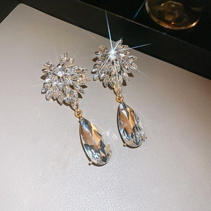 Vue macro détaillée des boucles d'oreilles goutte dorées avec cristaux marquises brillants