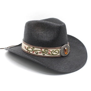 Détail d'un chapeau de cowboy en paille noire avec broderie ethnique et boucle en ambre