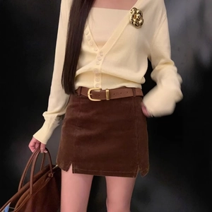 Women's brown corduroy mini skirt paired with beige knit cardigan for autumn style