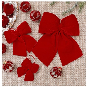 Detailed view of red velvet Christmas bows in various sizes with festive decorations