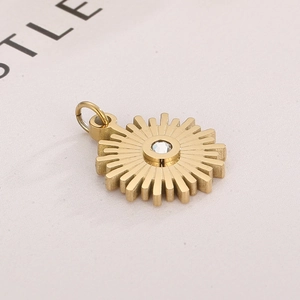 Macro shot of gold stainless steel sunburst pendant with a sparkling zircon stone inlay