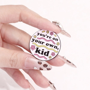 Pink enamel brooch with you're on your own kid text and floral details for bags