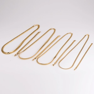 Five assorted gold-plated stainless steel flat snake chain necklaces on white background