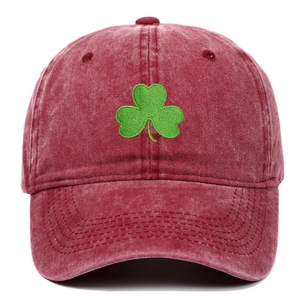 Close-up of green shamrock embroidery on a vintage washed burgundy cotton baseball cap