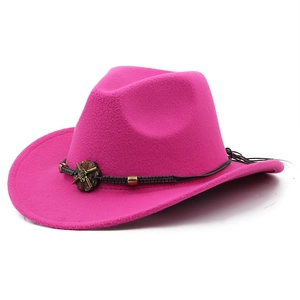 Detail of rose pink felt cowboy hat featuring dark braided band and vintage metal ornament