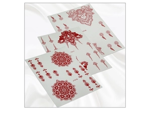 Detailed view of red henna lace mandala temporary tattoos on elegant white silk background