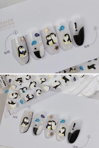 Detail of 3D penguin nail stickers with blue fish and embossed snowflakes patterns