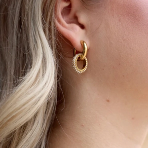 Close-up of 18K gold-plated chunky hoops with sparkling white zircon pave pendant detail