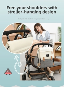 Nappy bag with stroller hooks being attached to a baby carriage in use