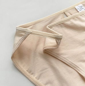 Close-up of beige cotton bikini underwear showing detailed stitching and fabric texture