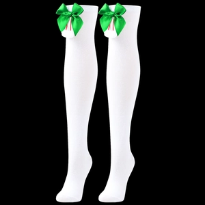 Detail of white over-the-knee socks featuring green satin bows and soft white pom-poms