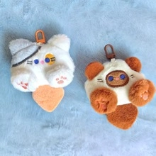 Close-up of plush cat and panda keychains with colorful metal clips on blue fabric